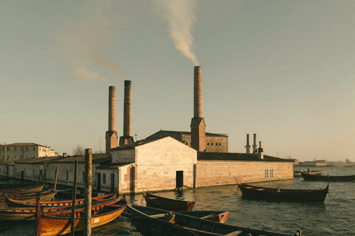 Old glass furnaces with tall chimneys along a canal on Murano