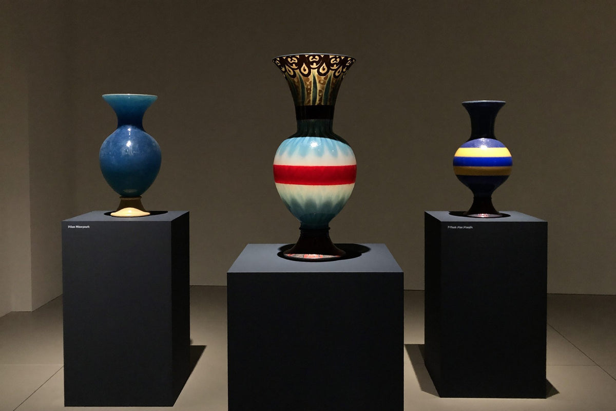 Trois vases d’art en verre de Murano sur des socles dans une galerie