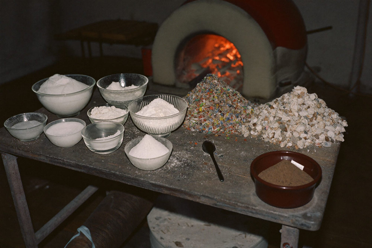 Silica sand, soda ash and coloured glass cullet beside a Murano furnace